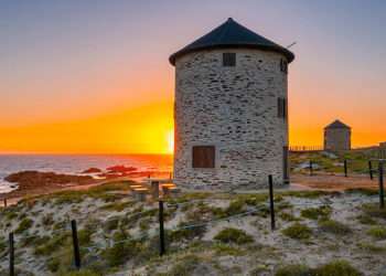 Uno de los molinos junto a la playa // iStock/Luis Pina