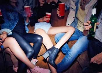 Jóvenes en una fiesta privada // iStock/shironosov