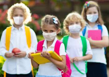 Niñas y niños portando la mascarilla en un centro escolar // iStock/FamVeld