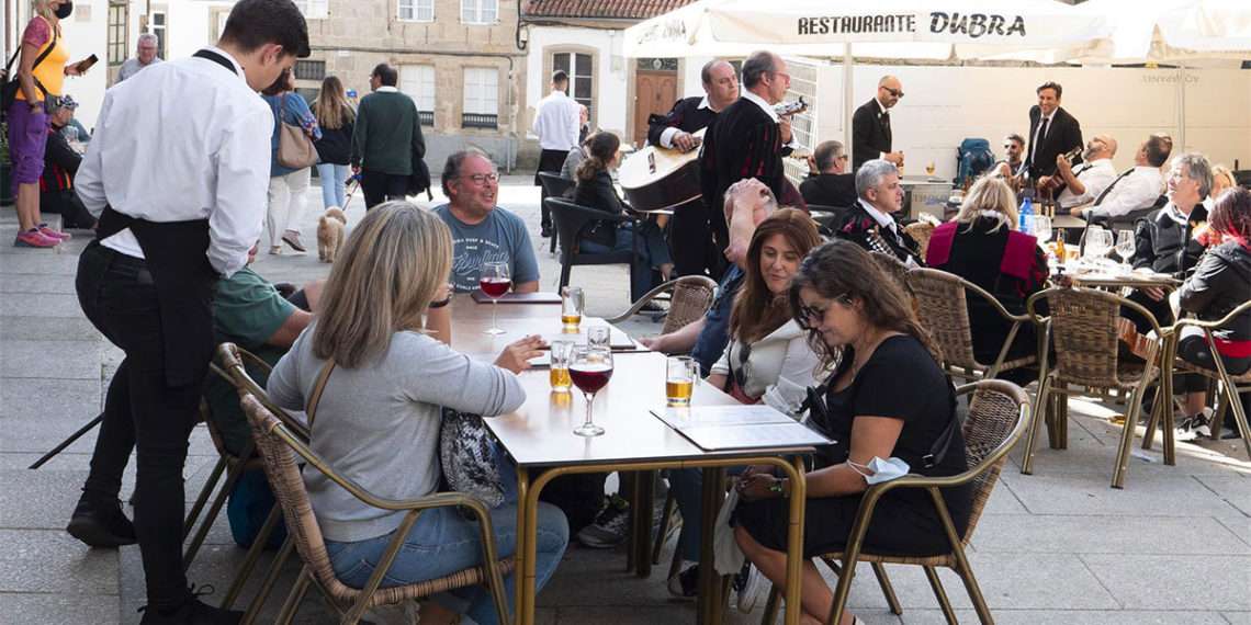 Archivo - Un grupo de turistas consulta una carta en la terraza de un bar en Santiago de Compostela. - César Arxina - Europa Press - Archivo