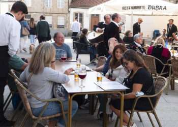 Archivo - Un grupo de turistas consulta una carta en la terraza de un bar en Santiago de Compostela. - César Arxina - Europa Press - Archivo
