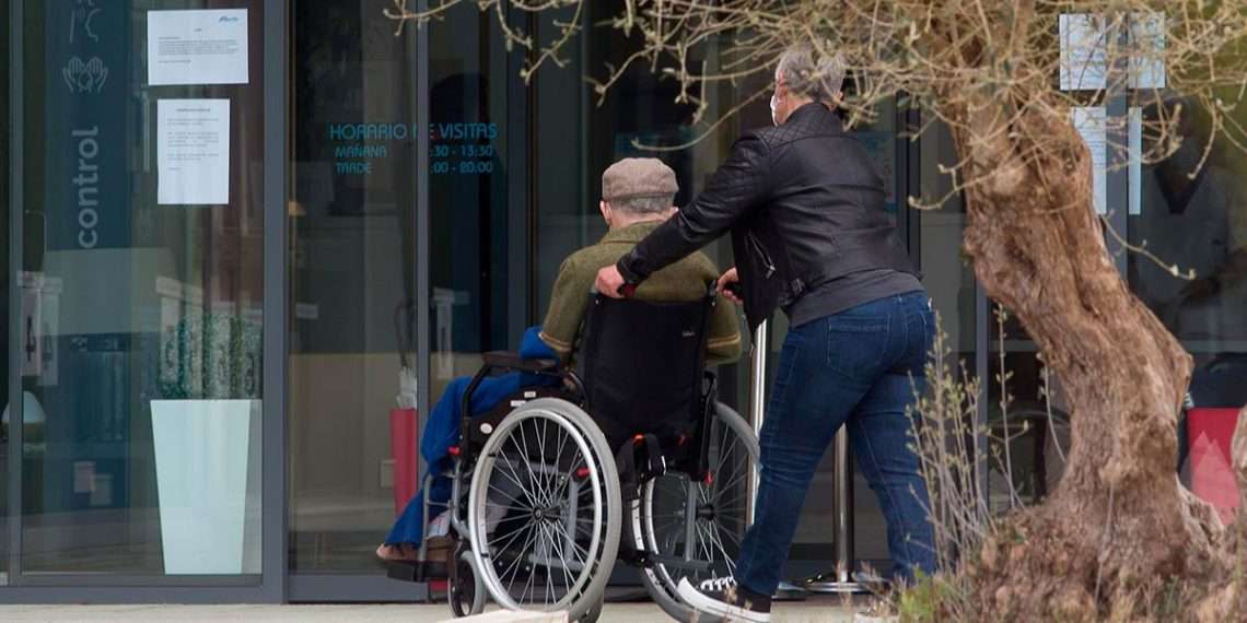 Una mujer pasea junto a un anciano en silla de ruedas hacia la residencia Albertia, a 17 de abril de 2021, en Lugo, // CARLOS CASTRO // EUROPA PRESS