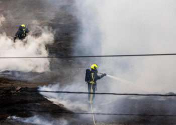 Dos bomberos trabajan en la extinción del fuego de la antigua fábrica de Pontesa, a 7 de noviembre de 2022, en Ponte Sampaio, Pontevedra // BEATRIZ CISCAR / EUROPA PRESS