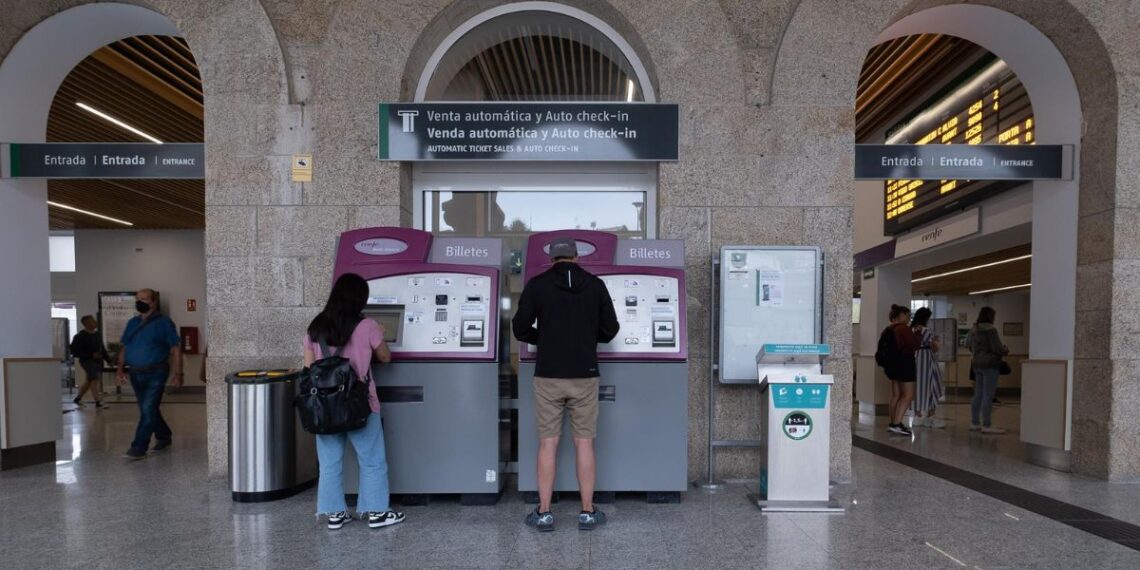 Dos personas compran billetes en los cajeros de venta automática en la estación de trenes en Santiago de Compostela. - César Arxina - Europa Press - Archivo