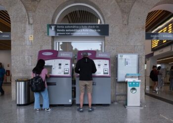 Dos personas compran billetes en los cajeros de venta automática en la estación de trenes en Santiago de Compostela. - César Arxina - Europa Press - Archivo