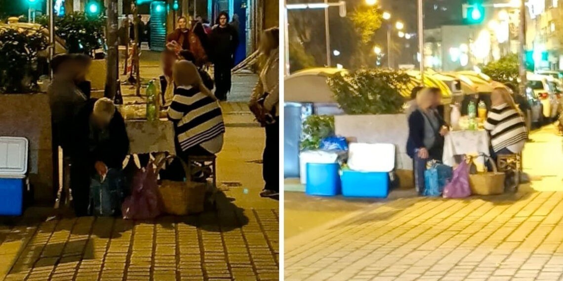 Insólita imagen de unos turistas en la Navidad de Vigo montando un picnic en la acera